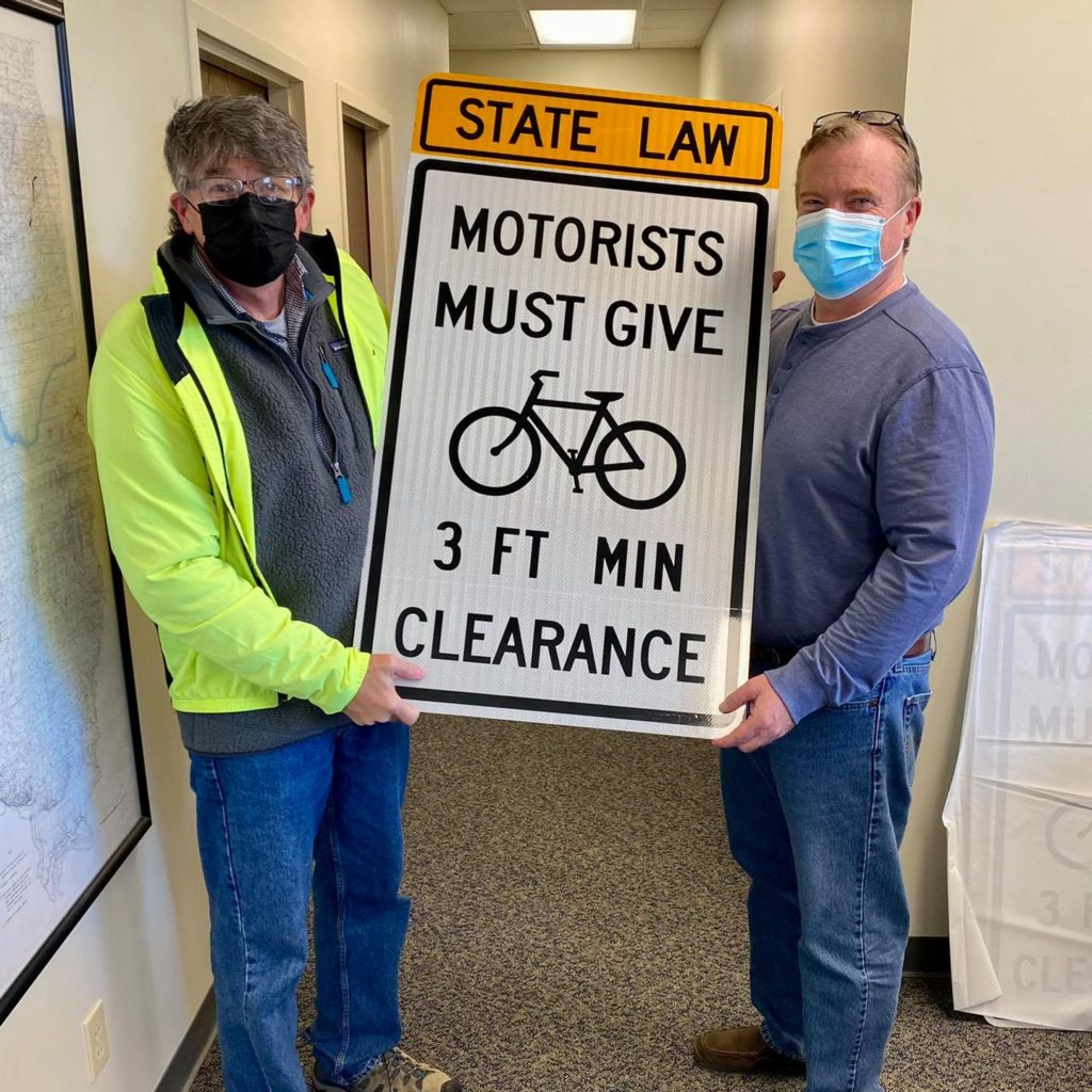 Jeff Yockey and Roland White holding 3 foot passing sign